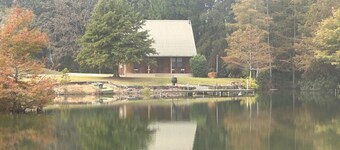 Cozy Cabin setting behind a 1 1/2 acre pond that is lined with Cypress Trees.