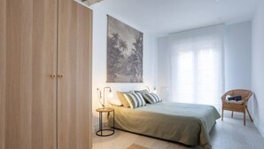A bedroom with a bed, a nightstand, a chair, and a wardrobe. - Aldatseta Home - Apartamento centrico (Bermeo)