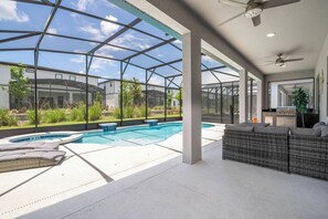 Un espace extérieur abrité avec une piscine, des chaises longues et un barbecue.