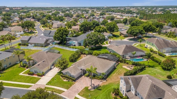 A residential area with houses, a swimming pool, and a well-maintained lawn.