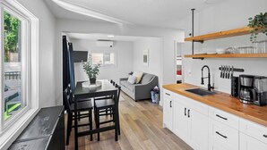 Une cuisine moderne avec des armoires blanches, un plan de travail en bois et un évier encastré.
