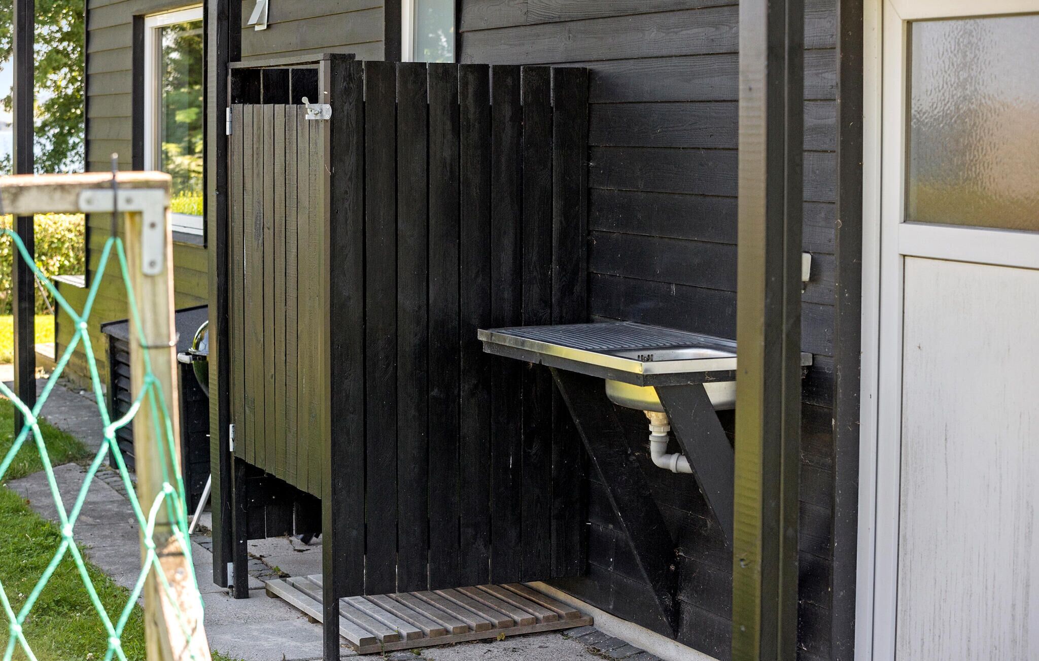 A small outdoor structure with a metal table and a step leading up to it.