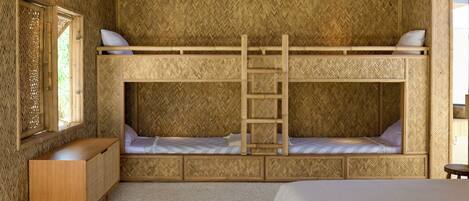 A bunk bed room with a ladder, a wooden dresser, and a window.