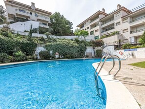 Relax by the rectangular pool surrounded by a concrete deck and lush greenery.