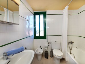 Bathroom features a sink, bidet, toilet, and bathtub with showerhead.