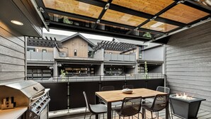 Eine moderne Außenpatio mit Grill, Esstisch und Stühlen.