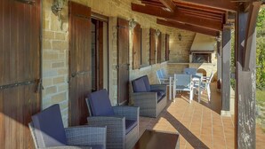 An outdoor patio with wicker furniture, stone walls, and a brick floor. - 3 bedroom cozy home in Villamblard (Villamblard)