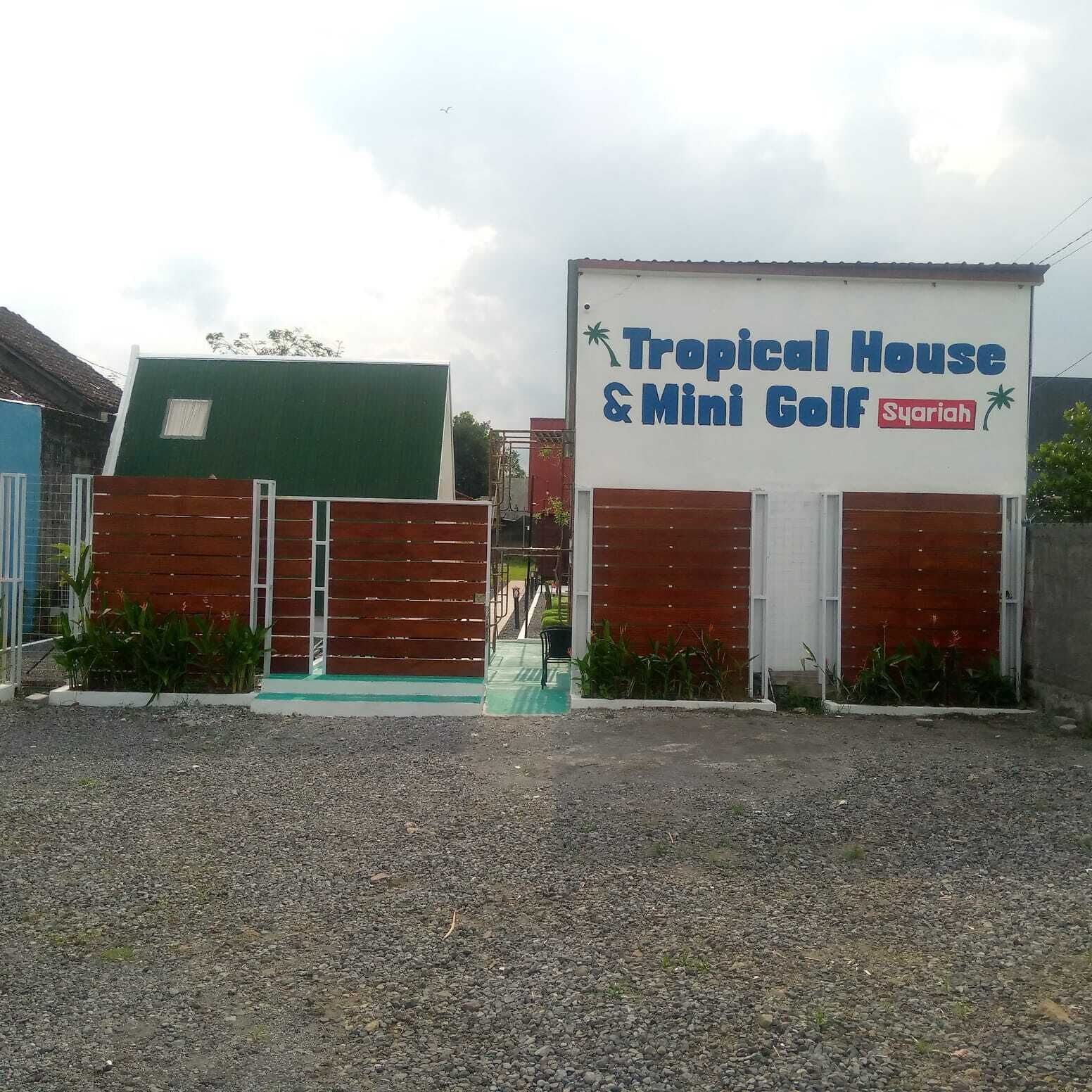 Un edificio con un cartello che recita 'Tropical House & Mini Golf Syariah'.