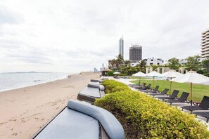 På stranden, vit sandstrand, solstolar och parasoller