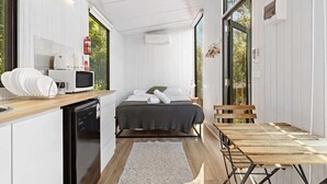 A compact bedroom with a bed, bedside table, and a small window. - Orange 2 by Tiny Away (Woori Yallock)
