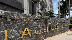 Un mur de pierre sur lequel est inscrit en lettres dorées le nom « LA GUNAHUE », indiquant qu’il s’agit d’un hôtel ou d’un complexe touristique.