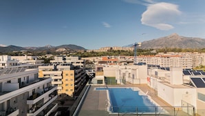 A rooftop swimming pool with a view of a residential area and mountains in the background. - Jardines Guadaiza 2 | Sea Views Terrace Bbq (Marbella)