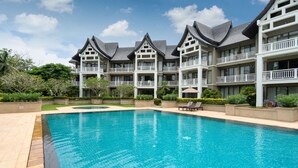 Un hôtel doté d’une piscine, de plusieurs balcons et d’un jardin.