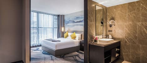 Une chambre d’hôtel moderne avec un grand lit, une salle de bain avec un miroir et une vue sur le paysage urbain.