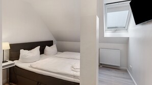 Une chambre à coucher avec un lit, une table de chevet, une lampe et une fenêtre donnant sur un beau paysage.