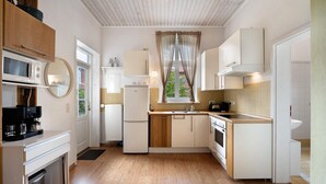 Una cocina compacta con microondas, cafetera y lavabo.