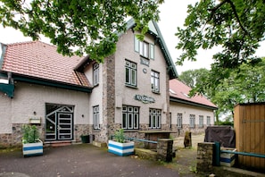 Un bâtiment à la façade en pierre, doté de nombreuses fenêtres et d’une enseigne portant l’inscription « Felsenburg ».