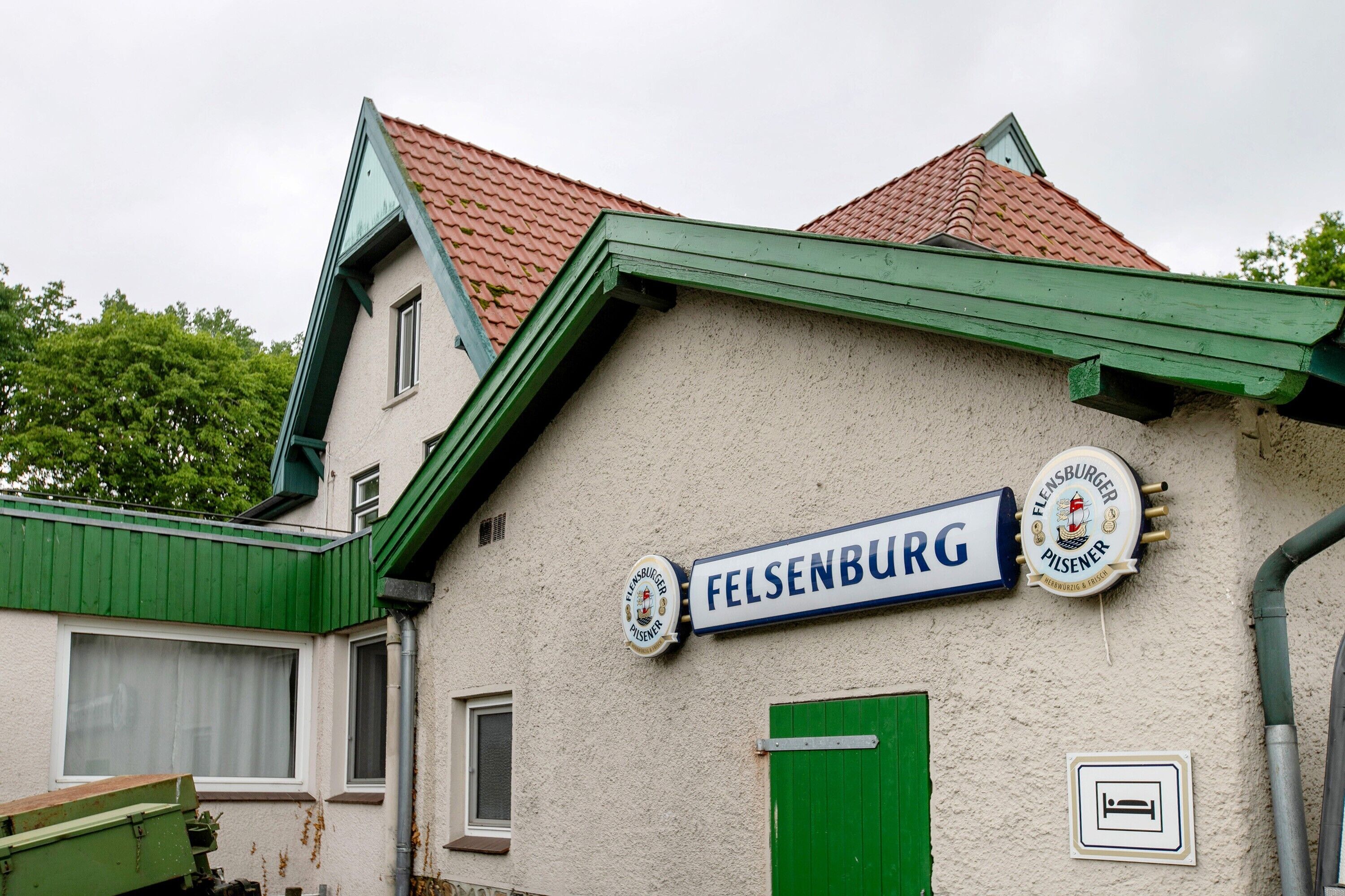 Un bâtiment sur lequel on peut lire l’inscription « Felsenburg » et qui arbore un logo de marque de bière.