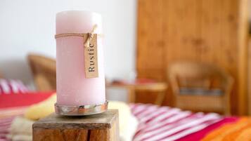 Vaaleanpunainen kynttilä, jossa on puupalikkaan kiinnitettynä etiketti, jossa lukee ”Rustic”.