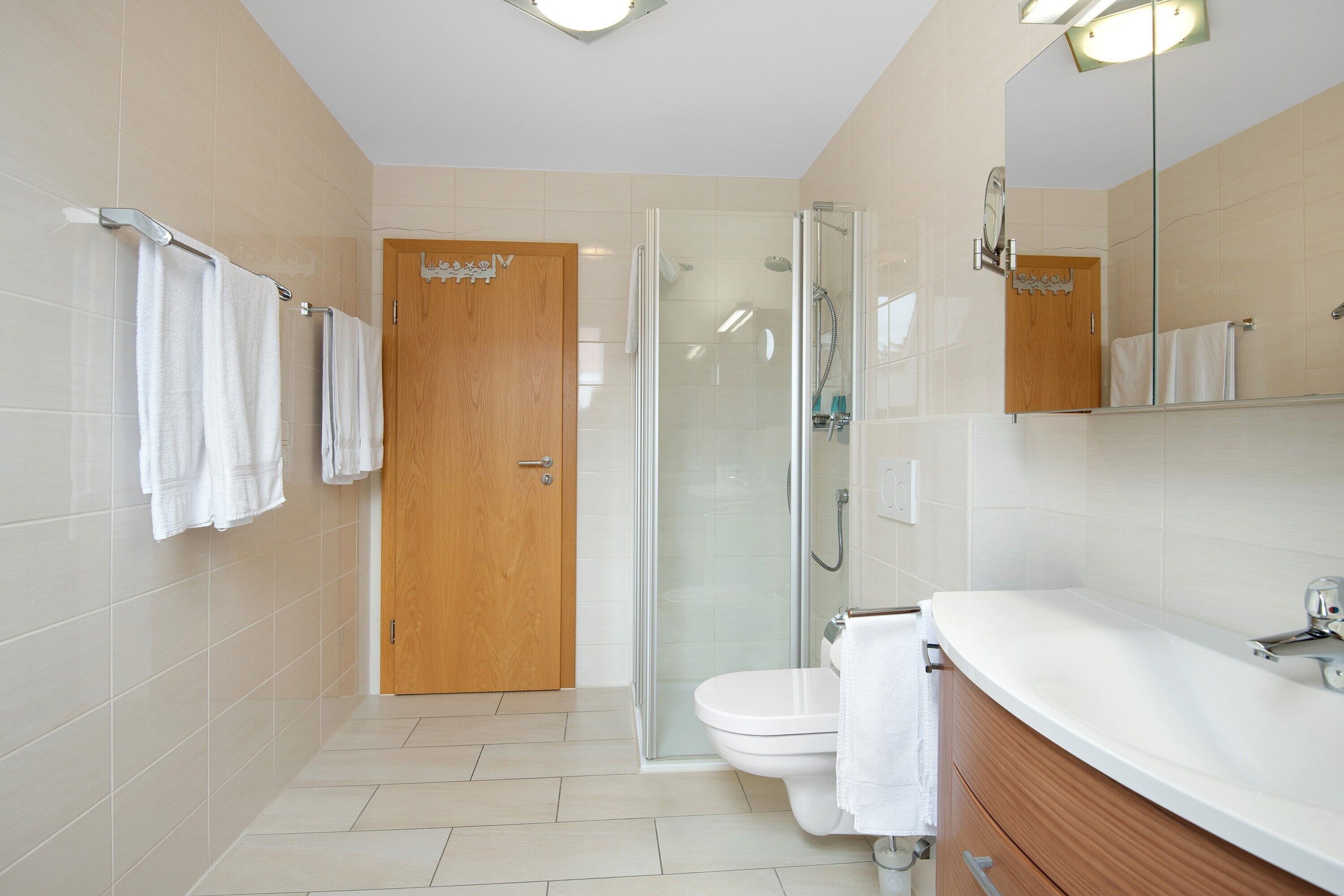 Une salle de bain avec douche, toilettes et lavabo.