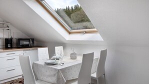En matplats med ett bord för fyra personer, en mikrovågsugn och en kaffemaskin.