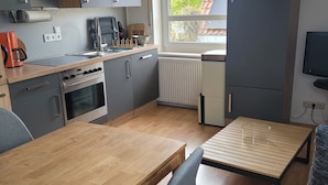 Ett modernt kök med matplats, en inbyggd ugn och ett fönster med utsikt över omgivningen.