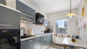 Una cocina moderna con horno integrado, microondas y lavabo.