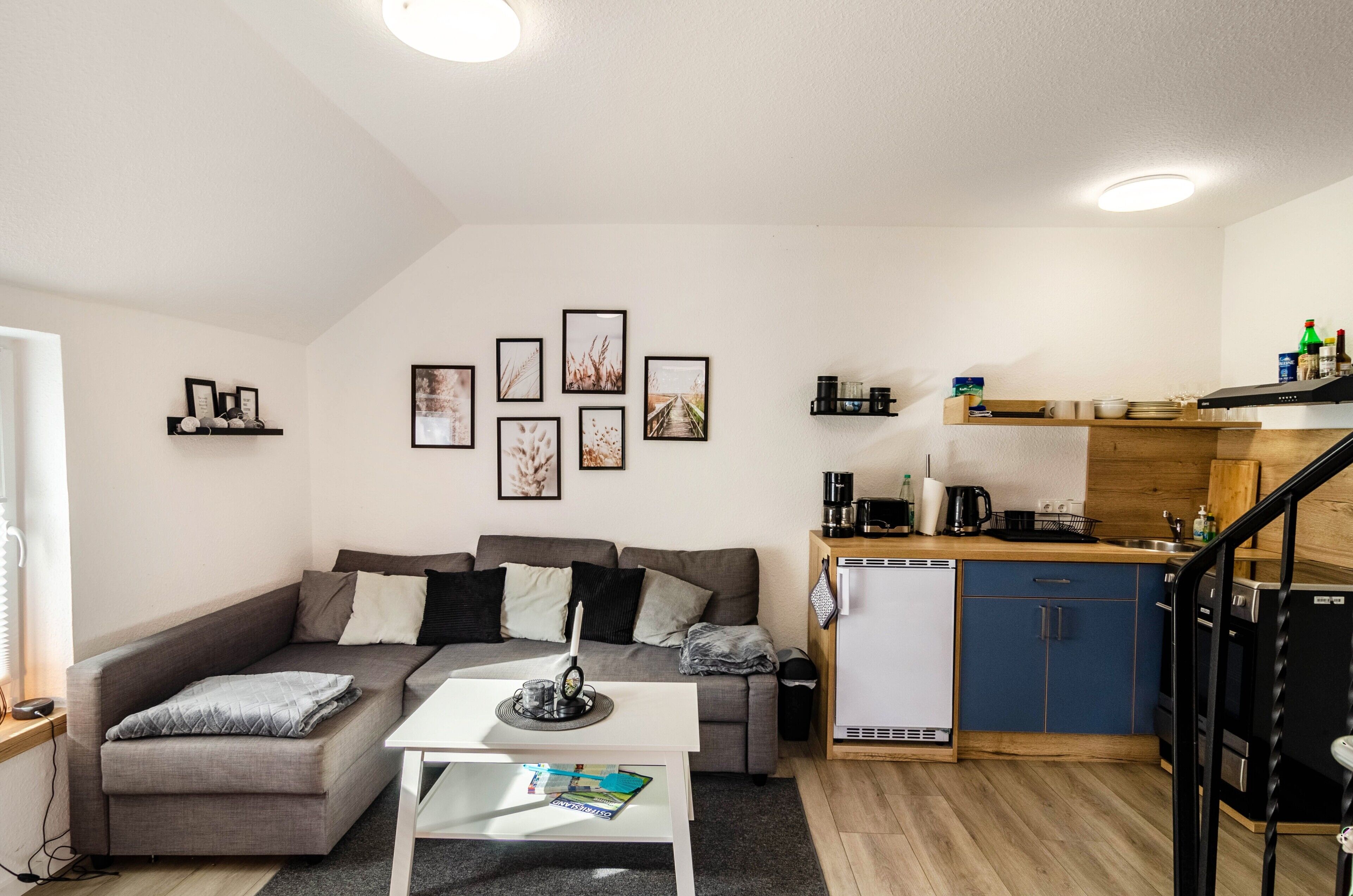 Ein kompakter Wohnbereich mit einer Couch, einem Couchtisch und einer Küchenzeile.