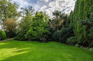 A well-maintained garden with a lawn, a wooden table, and chairs. - Apartment 'Didi' with Shared Terrace, Shared Garden and Wi-Fi (Detern)