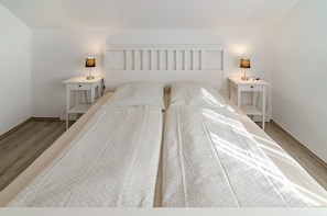 A twin bed with a headboard, two bedside tables, and lamps. - Apartment 'Lotte' with Shared Terrace, Shared Garden and Wi-Fi (Detern)
