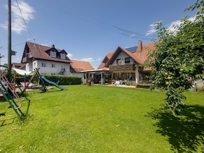 A residential area with two houses, a playground, and a garden.