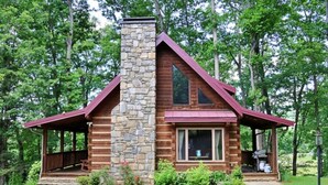 Eine Holzhütte mit Steinofen, Holzfassade und überdachter Veranda.
