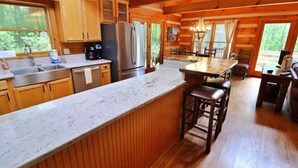 A spacious kitchen with wooden cabinets, a marble countertop, and a stainless steel refrigerator. - The Hilltop: 6 Minutes to Hiking, Casino & Golf (Whittier)