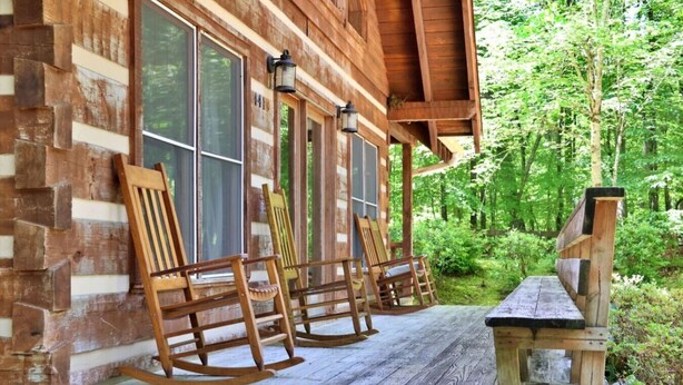 A wooden cabin with a porch, rocking chairs, and a bench. - The Hilltop: 6 Minutes to Hiking, Casino & Golf (Whittier)