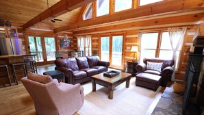 A cozy log cabin interior with a living room, dining area, and kitchen. - The Hilltop: 6 Minutes to Hiking, Casino & Golf (Whittier)
