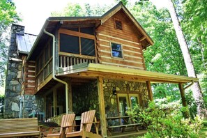 A log cabin with a stone foundation, a balcony, and a porch with two chairs. - The Ridge: 6 mins to Casino+PetFriendly+Gas Grill (Whittier)