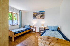 A room with two wooden beds, a window with curtains, a painting on the wall, and two bedside lamps. - Apartment 'Ferienwohnung Mit Bergblick' with Mountain View, Private Terrace and Wi-Fi (Edling)