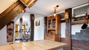 Uma cozinha rústica com uma mesa de madeira, armários e um relógio.