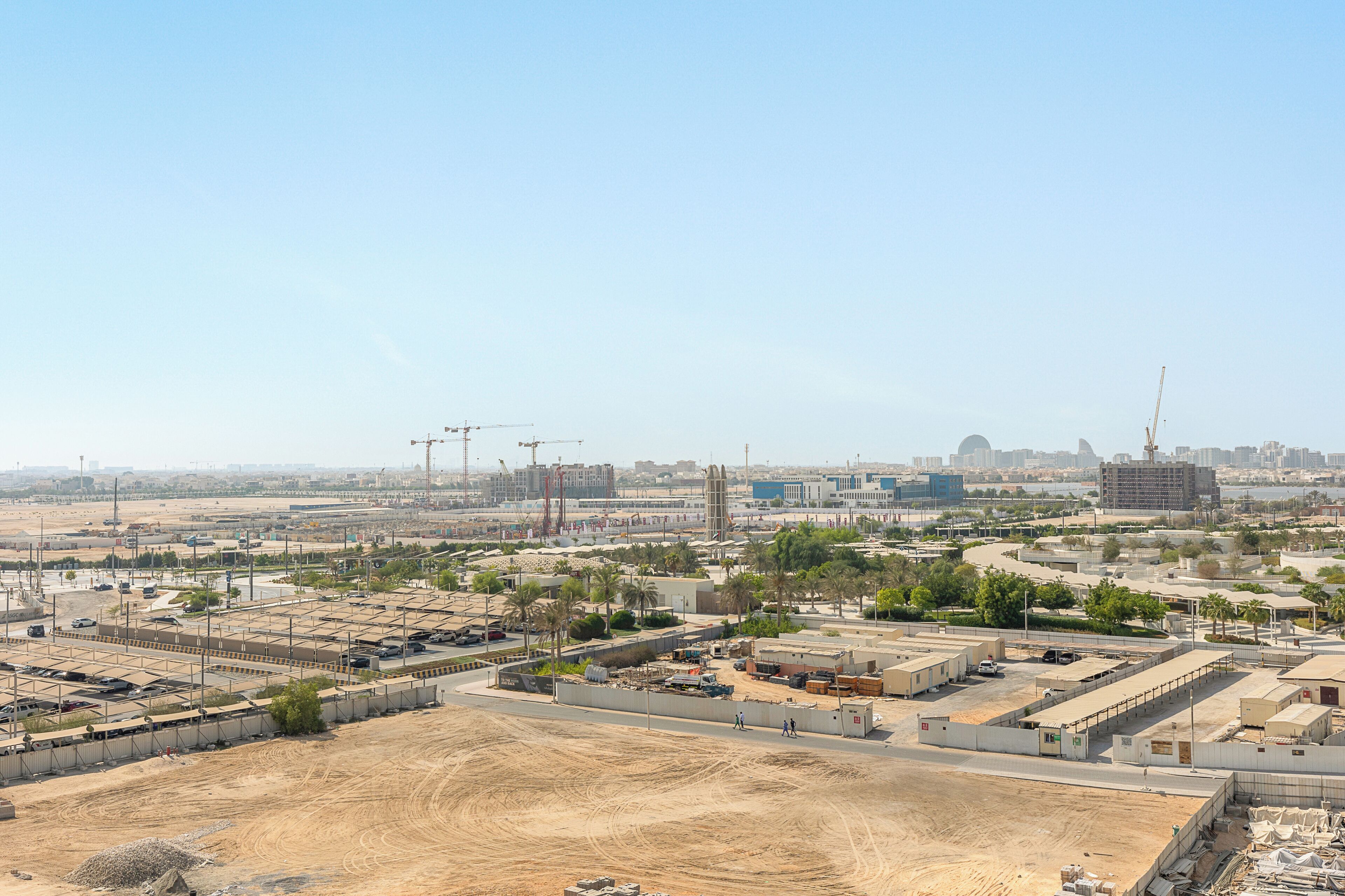 A large industrial area with multiple buildings, some under construction, and a clear sky.