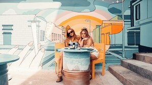 Two people sitting at a table with a large barrel in the foreground. - The Hangout Ao Nang (Krabi)