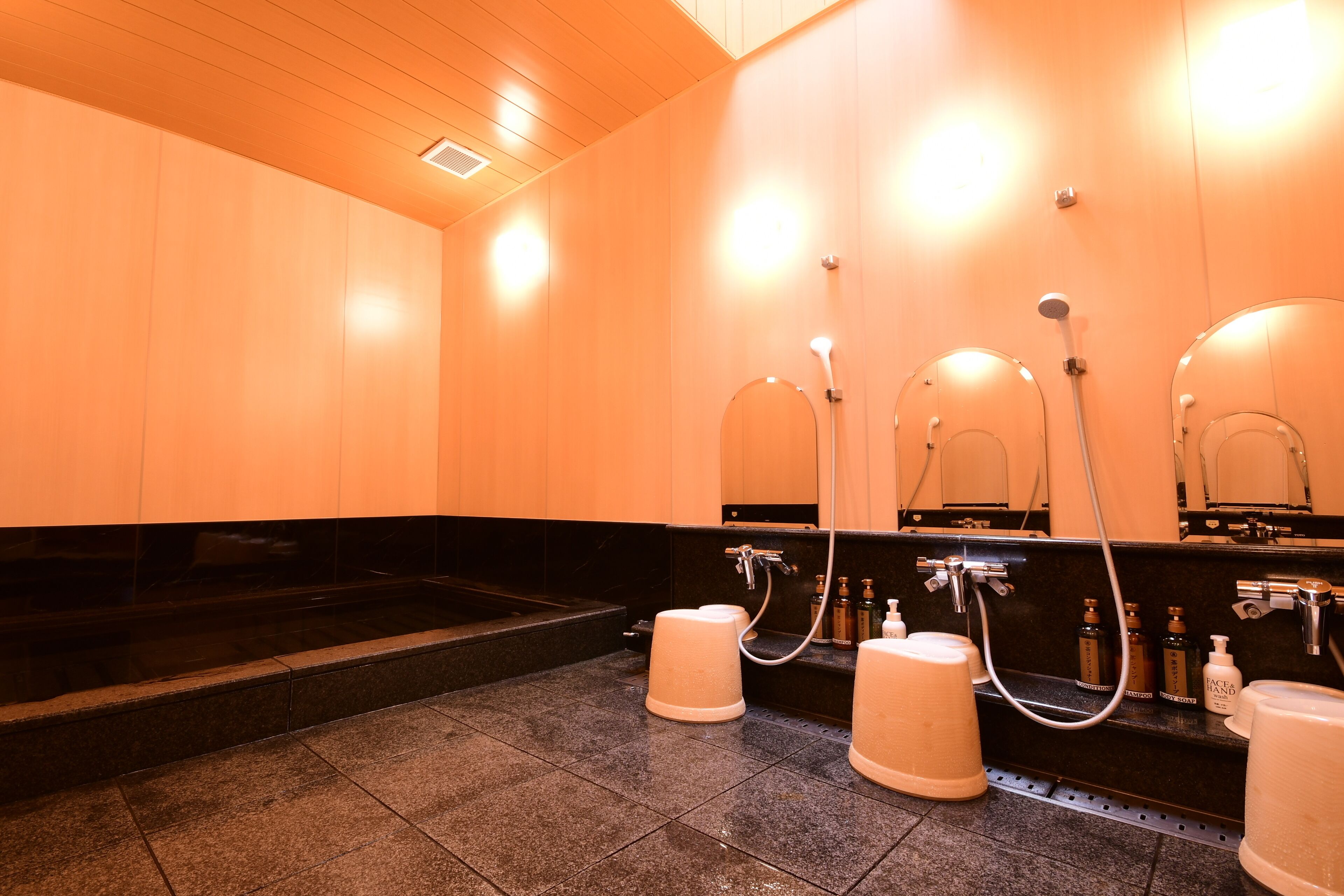 A modern bathroom with three sinks, a large mirror, and a heated floor.