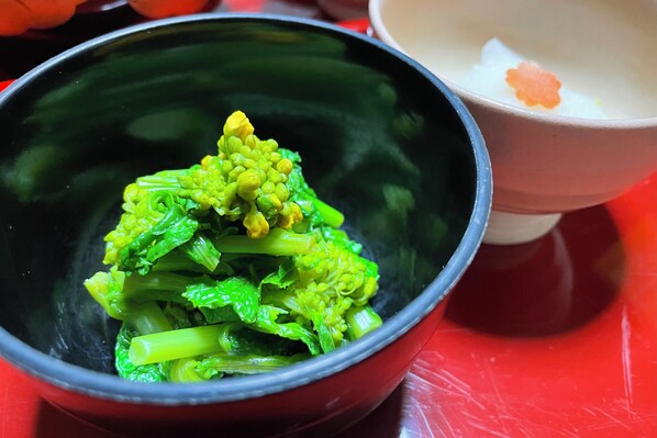 A bowl of green vegetables, possibly broccoli, with a red bowl beside it. - Koyasan Shukubo Yochiin (Koya)