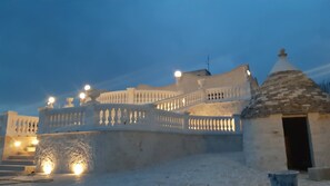 A historic building with a white facade, a stone dome, and a balcony with lights. - Villa Clara Alberobello (Alberobello)