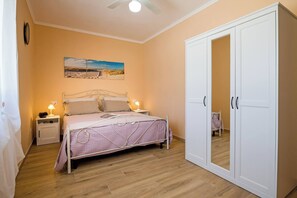 A bedroom with a bed, bedside tables, a wardrobe, and a ceiling fan. - Villa Clara Alberobello (Alberobello)