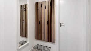Een badkamer met een wand van houten latten, een spiegel en een deur.