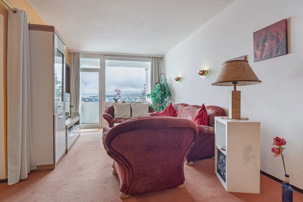 Una sala de estar moderna con un sofá, una lámpara y vistas a la ciudad.