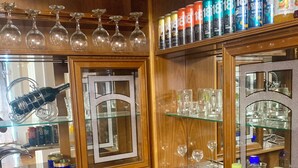 A bar area with shelves of energy drinks, glasses, and a bottle of alcohol. - Karvan-N (Tashkent)