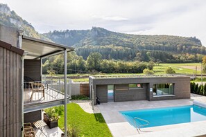 A modern two-story house with a pool, a balcony, and a view of a forested mountain. - Nadou – Lupus 5 Holiday Home in the Upper Danube Valley (Beuron)