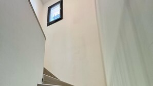 A staircase with wooden steps and a small window at the top. - Superb house with garden and swimming pool close to transport links  (Avignon)