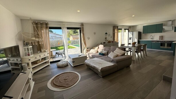 A modern living room with a sofa, TV, and dining area. - Superb house with garden and swimming pool close to transport links  (Avignon)